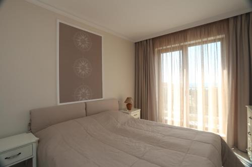 a bedroom with a bed and a large window at Villa Allegra in Kavarna