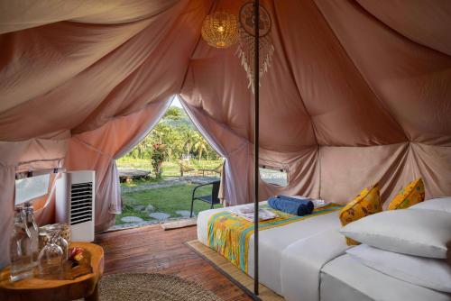 um quarto com uma cama numa tenda em Natya River Sidemen em Silebeng