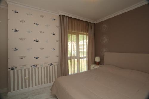 a bedroom with a white bed and a window at Villa Allegra in Kavarna
