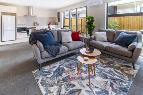 a living room with a couch and a table at 3 Bed 2.5 Bath Riccarton W/Games room in Christchurch