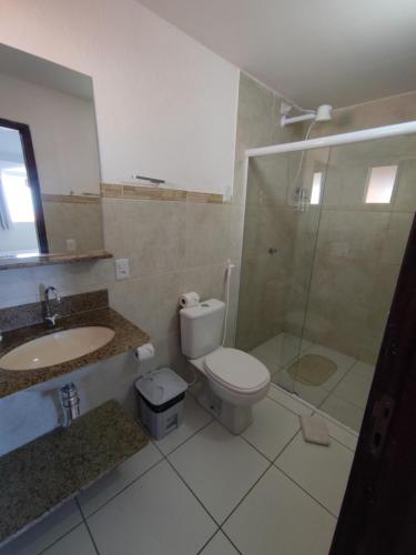 a bathroom with a toilet and a sink and a shower at Encanto da Praia hotel pousada in Natal