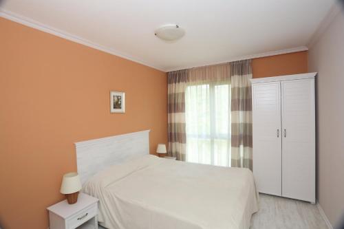 a bedroom with a white bed and a window at Villa Allegra in Kavarna