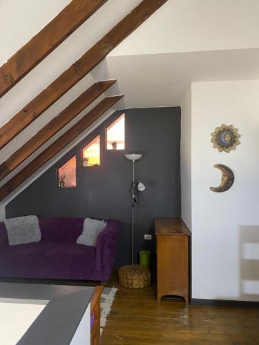 una sala de estar con un sofá púrpura en un ático en Hermosa Parcela en Concón, en Concón