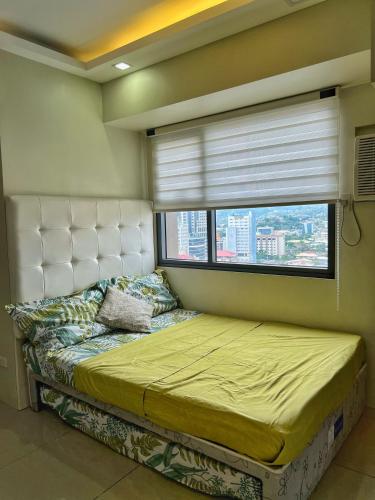 a bedroom with a large bed with a window at Horizons 101 Condo in Cebu City in Cebu City