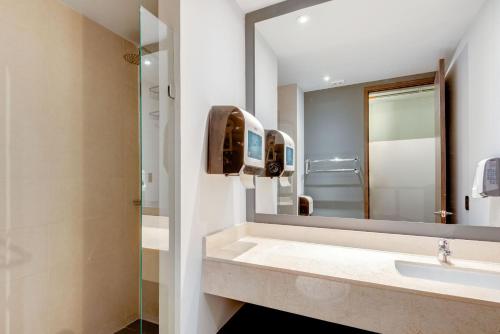 ein Bad mit einem Waschbecken und einem Spiegel in der Unterkunft Selina Parque 93 Bogota in Bogotá