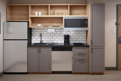 a kitchen with a sink and a microwave at Candlewood Suites - Layton - Salt Lake City by IHG in Layton