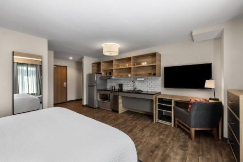 a hotel room with a bed and a kitchen at Candlewood Suites - Layton - Salt Lake City by IHG in Layton