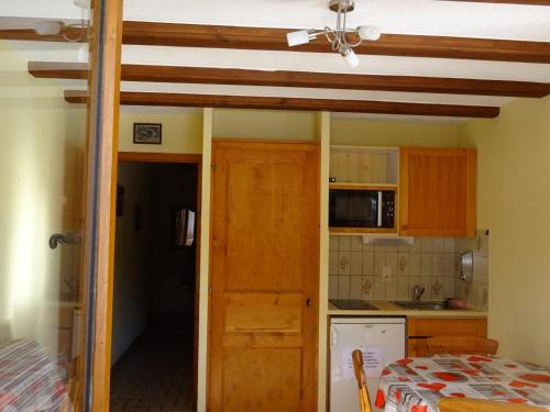 une cuisine avec une table et un ventilateur de plafond dans l'établissement Studio pour 4 pers., balcons, près des remontées mécaniques à Châtel - FR-1-676-149, à Châtel