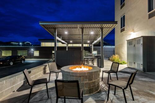 an outdoor patio with a fire pit and chairs at Candlewood Suites - Layton - Salt Lake City by IHG in Layton