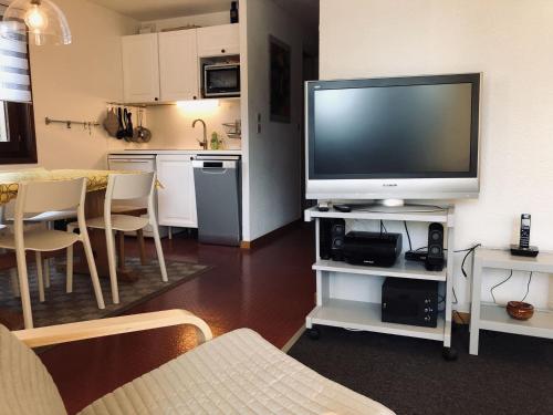 un salon avec une télévision à écran plat sur un meuble dans l'établissement Chalet cosy 2 pièces avec WIFI et parking - 1km du village - FR-1-676-150, à Châtel