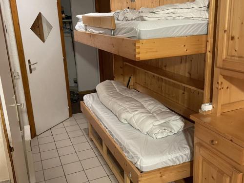 Ce dortoir comprend 2 lits superposés et une porte. dans l'établissement Appartement cosy 3 pièces pour 6 pers., proche télécabine Linga, balcon, garage, animaux admis - FR-1-676-158, à Châtel