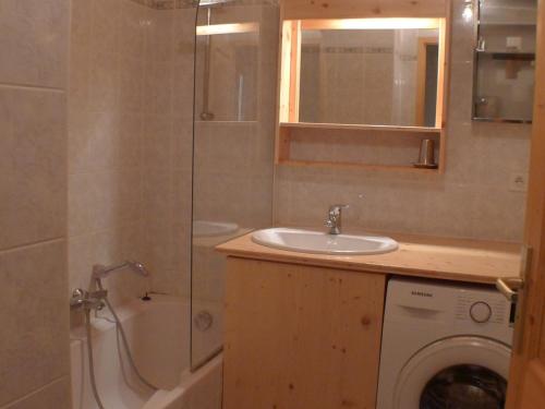 een badkamer met een douche, een wastafel en een wasmachine bij Appartement Samoëns, 4 pièces, 6 personnes - FR-1-629-133 in Samoëns