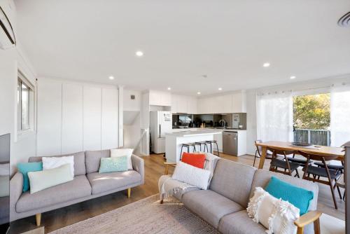 a living room with two couches and a dining room at Seaspray Getaway in Cape Woolamai