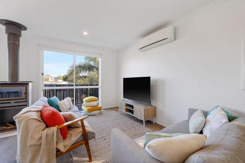 a living room with a couch and a tv at Seaspray Getaway in Cape Woolamai