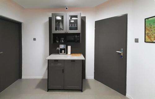 a kitchen with a counter and a black door at Trzy Kolory in Polanica-Zdrój