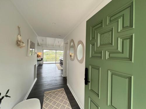 un corridoio con porta verde in una casa di Rye Beach House - Sunset Views a Rye