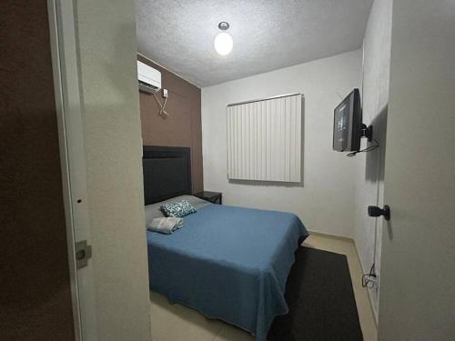 a bedroom with a blue bed and a television at ¡Descubre tu oasis en Acapulco! Casa vacacional. in Acapulco
