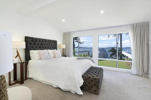 a bedroom with a large bed and a large window at Boat Harbour Haven in Bonnells Bay