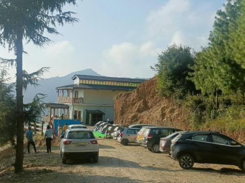 a group of cars parked on a dirt road in front of a building at Veda Inn in Chakrāta