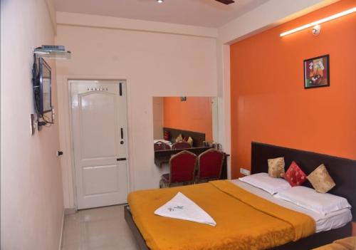 a bedroom with a bed with an orange wall at N K F Residency in Mysore