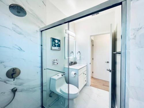 La salle de bains est pourvue de toilettes et d'une douche en verre. dans l'établissement Sunnyvale Cozy New 3B3b home/Gogle/speed WiFi, à Sunnyvale