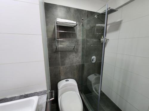 a bathroom with a toilet and a glass shower at Departamento en barranco 2 in Lima