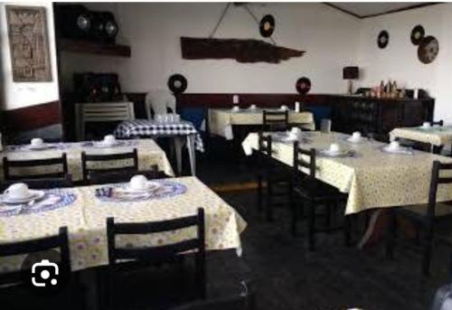 een eetkamer met tafels en stoelen in een kamer bij POUSADA ODARA à Beira Mar in Saquarema