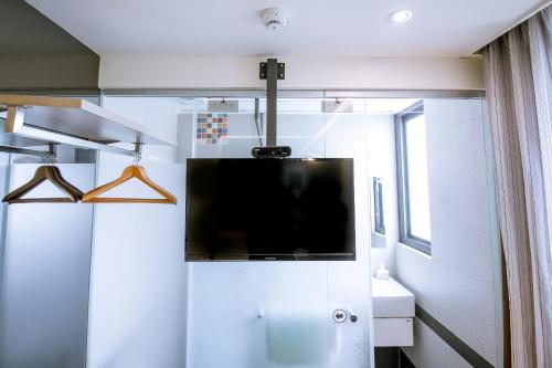 a bathroom with a flat screen tv on a wall at CHECK inn Express Taichung FuXing Hall 2 in Taichung