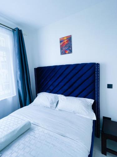 KiambuOne bed airbnb with pool by Omuts的卧室里有一张带蓝色床头板的床