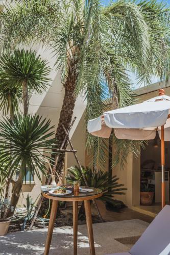 a table and an umbrella and some palm trees at Casa Solana in Patong Beach