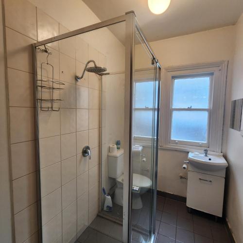 a bathroom with a shower and a toilet and a window at 50 Green St Windsor in Melbourne