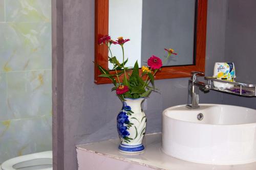 a blue and white vase with flowers on a sink at Sabay Farm in Kampot