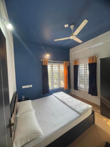 a bedroom with a bed with a ceiling fan at Royal residency in Tindummal