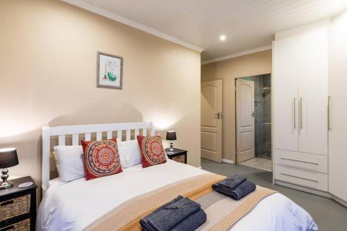 a bedroom with a bed and a walk in shower at Gasteria Cottage in Dana Bay