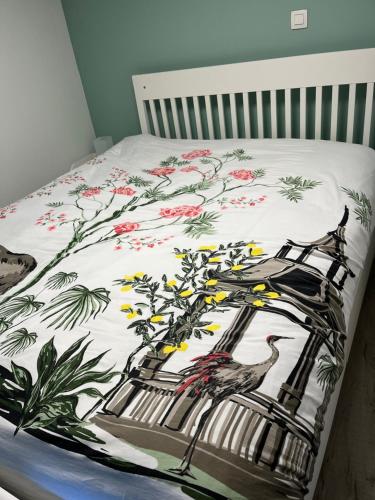 uma cama com um cobertor com um pássaro em Au chant du cocq em Binche