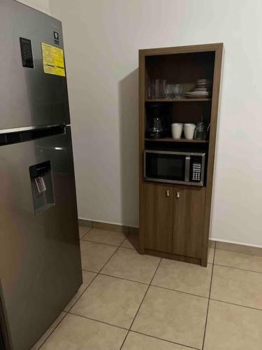 a kitchen with a refrigerator and a microwave at Apartamentos Trebol in Comayagua