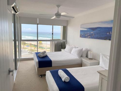 a bedroom with two beds and a view of the ocean at Hi Surf Beachfront Resort Apartments in Gold Coast