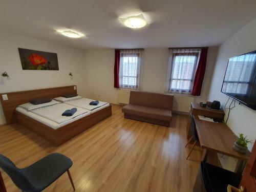 1 dormitorio con cama, sofá y TV en Citylife Rooms, en Mosonmagyaróvár