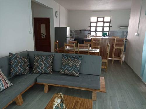 a living room with a blue couch and a kitchen at Peaceful house and environment in Souillac