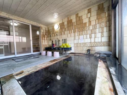 a bathroom with a pool of water in a room at Masuya Ryokan in Nozawa Onsen