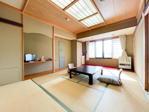 a living room with a table and a window at Masuya Ryokan in Nozawa Onsen