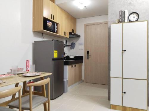 a kitchen with a table and a refrigerator at C226 Place at SMDC Cheer Residences by Lee Portum in Marilao