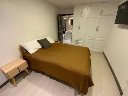 ein Schlafzimmer mit einem großen Bett und weißen Schränken in der Unterkunft Bonito apartamento remodelado en excelente sector in Cuenca