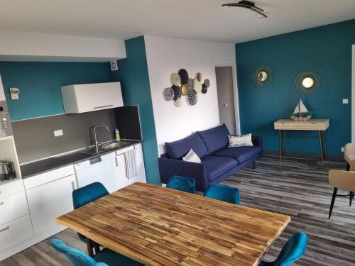 een woonkamer met een tafel en een blauwe bank bij Sainte Cécile: appartement 2ch 6/7 pers in Camiers