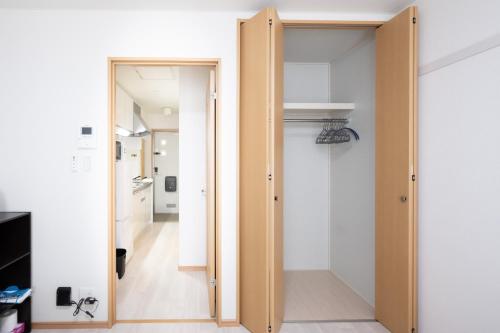 a hallway with a door leading to a kitchen at 駅近徒歩3分。生活に便利なアパート。長期滞在にもオススメ in Daitō