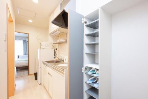 a kitchen with a sink and a refrigerator at 駅近徒歩3分。生活に便利なアパート。長期滞在にもオススメ in Daitō