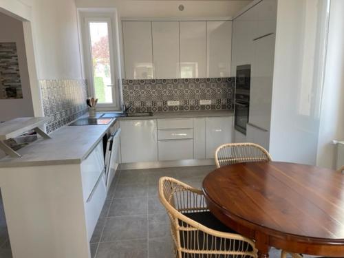 a large kitchen with a wooden table and chairs at MAISON VENEUX LES SABLONS-FONTAINEBLEAU-MORET SUR LOING in Veneux-les-Sablons