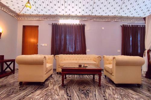a living room with two couches and a table at The Sky Imperial Nakoda Green Valley Resort in Nāthdwāra