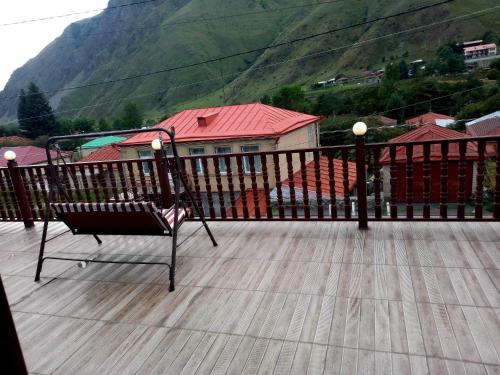a chair sitting on a deck with a view of a mountain at Come & Rest in Stepantsminda