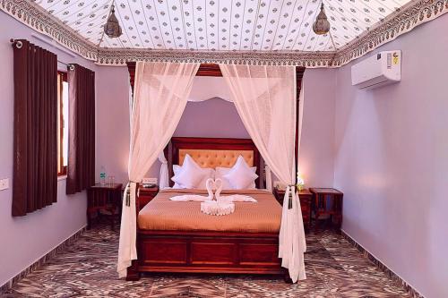 a bedroom with a bed with a canopy at The Sky Imperial Nakoda Green Valley Resort in Nāthdwāra